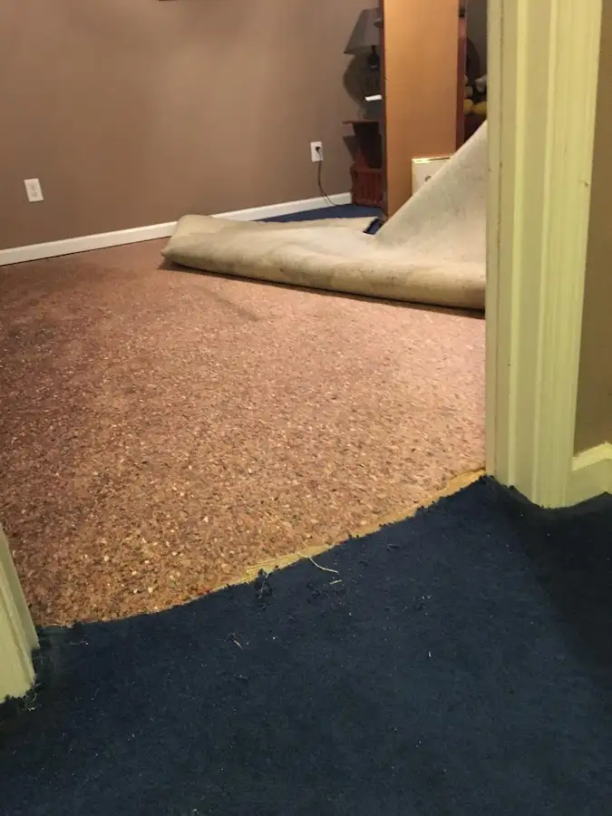 Carpet pad removal revealing water damage during Drying & Dehumidification in Arab